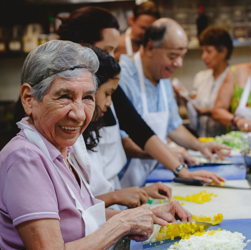 Person smiling chopping onions and peppers