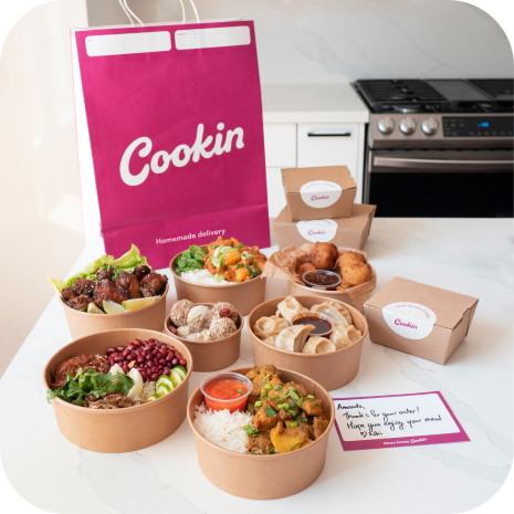 A counter full of ready to deliver food and a Cookin bag.